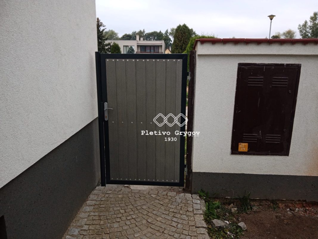 Šedá branka u vstupu na zahradu u rodinného domu