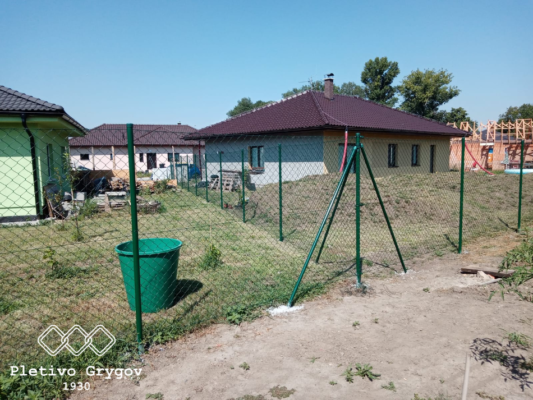 Plot z běžného pletiva kolem rodinného domu