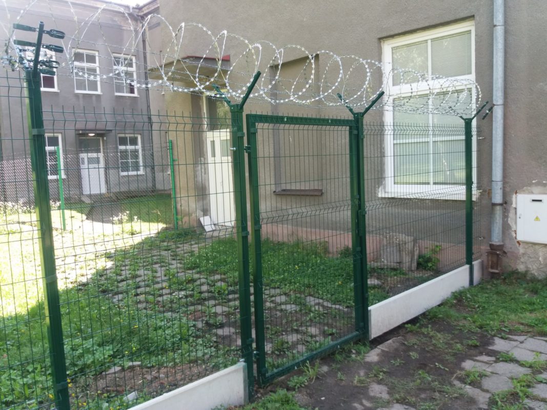Oplocení z 3D panelů s ostnatým drátem u firemního objektu