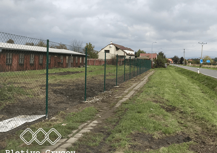 Plot z běžného pletiva kolem firemního pozemku