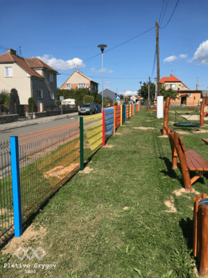 Oplocení z barevných 3D panelů okolo hřiště školky