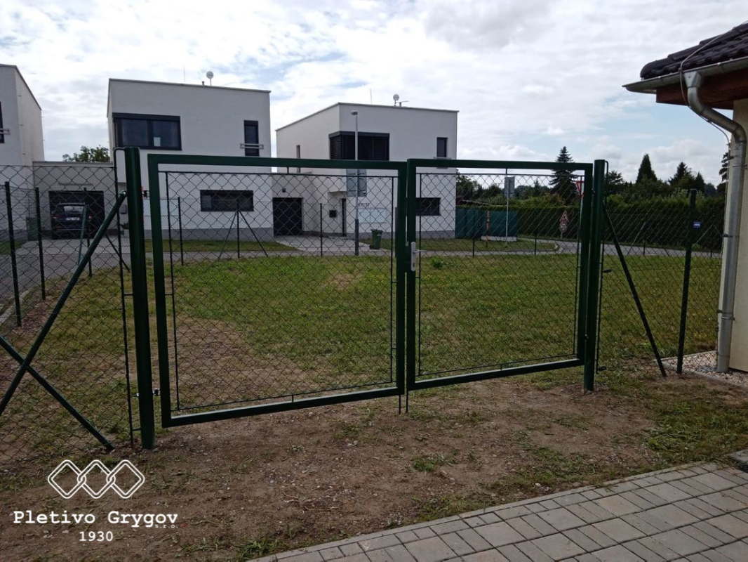 Zelená vstupní brána s plotem z 3D panelů kolem zahrady u rodinného domu