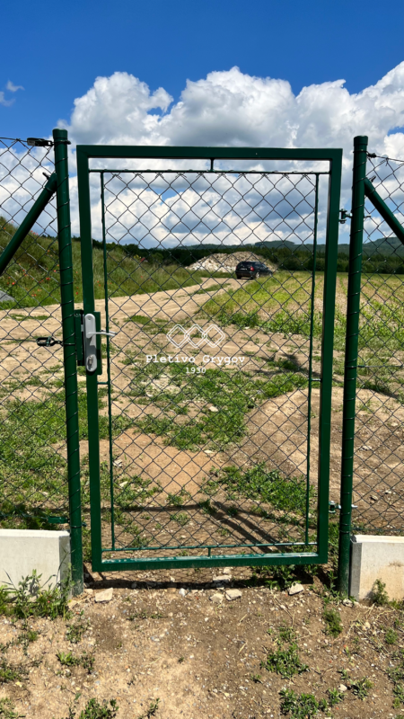 Zelená branka pro vstup do průmyslového objektu