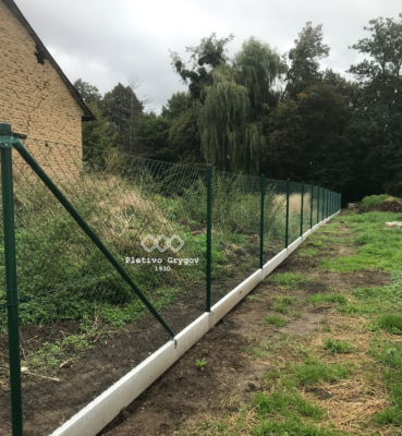 Oplocení z klasikého pletiva s podhrabovými deskami okolo zahrady