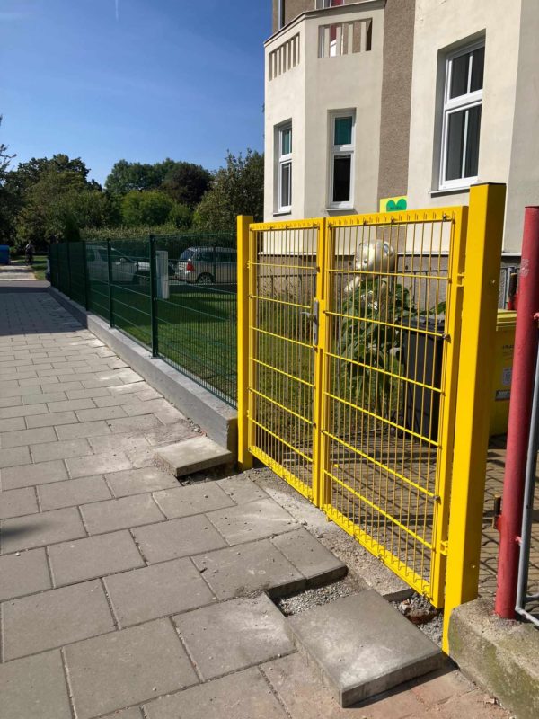 Žlutá branka u vstupu do firemního objektu