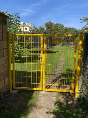 Žlutá branka u vstupu na zahradu v soukromém objektu