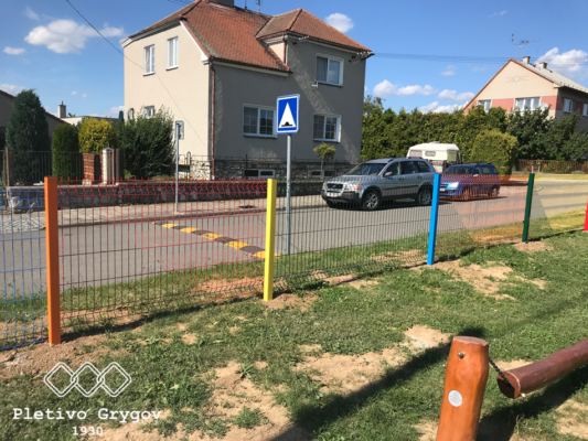 Oplocení z barevných 3D panelů okolo hřiště školky