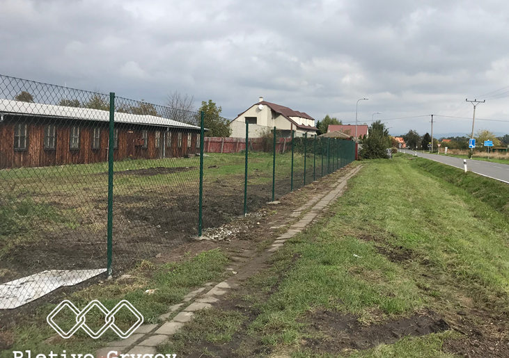 Plot z běžného pletiva kolem firemního pozemku